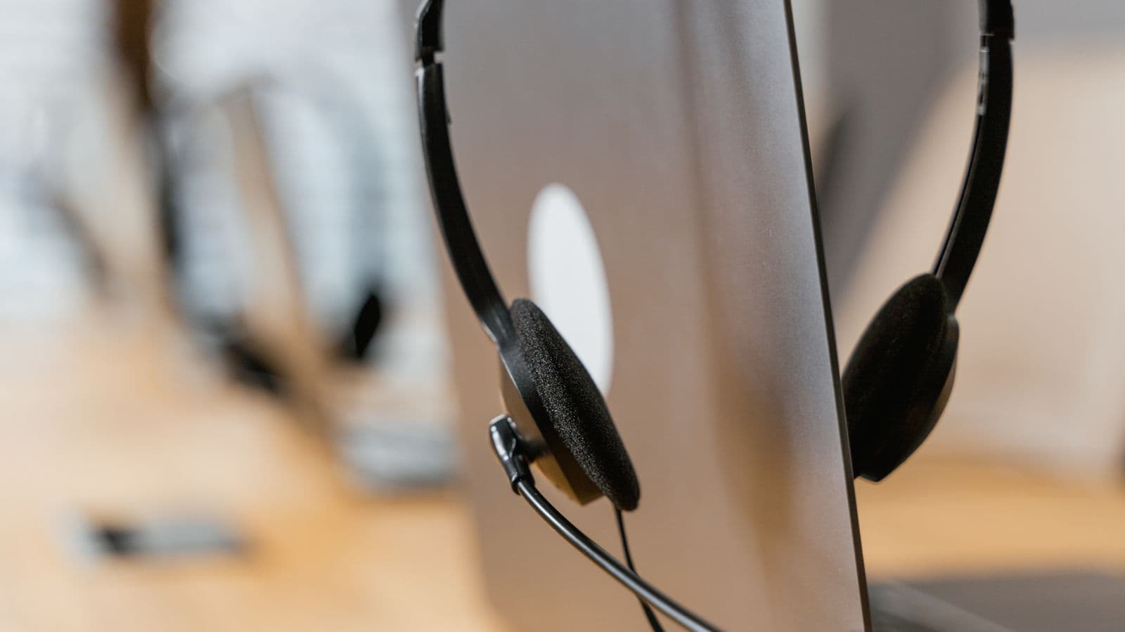 A customer-service headset resting on a desktop monitor