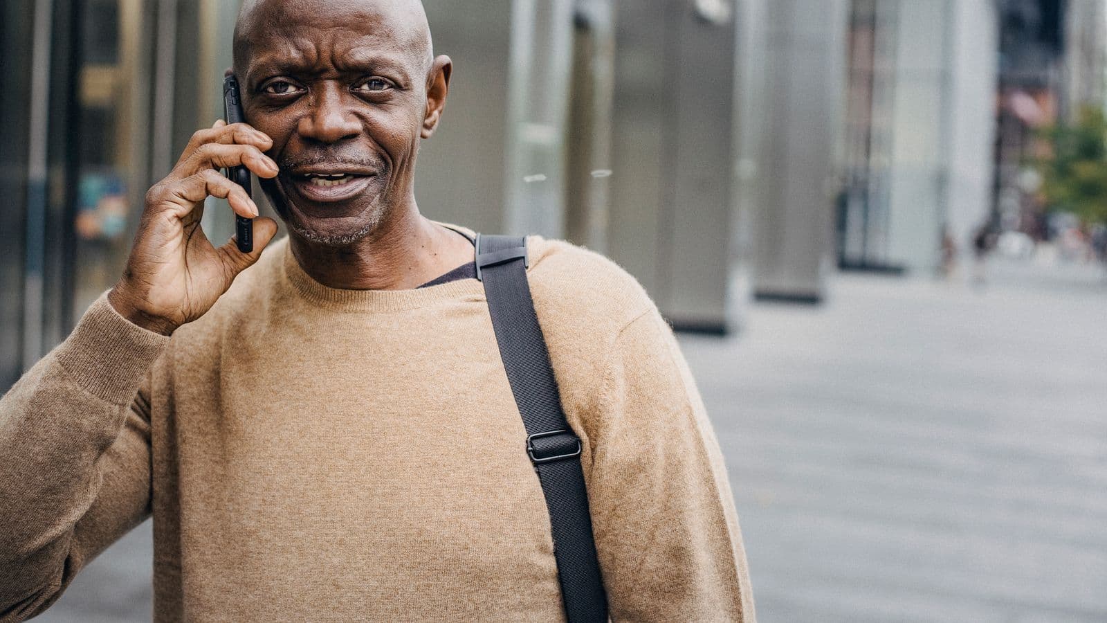 A man taking a phone call on a city street